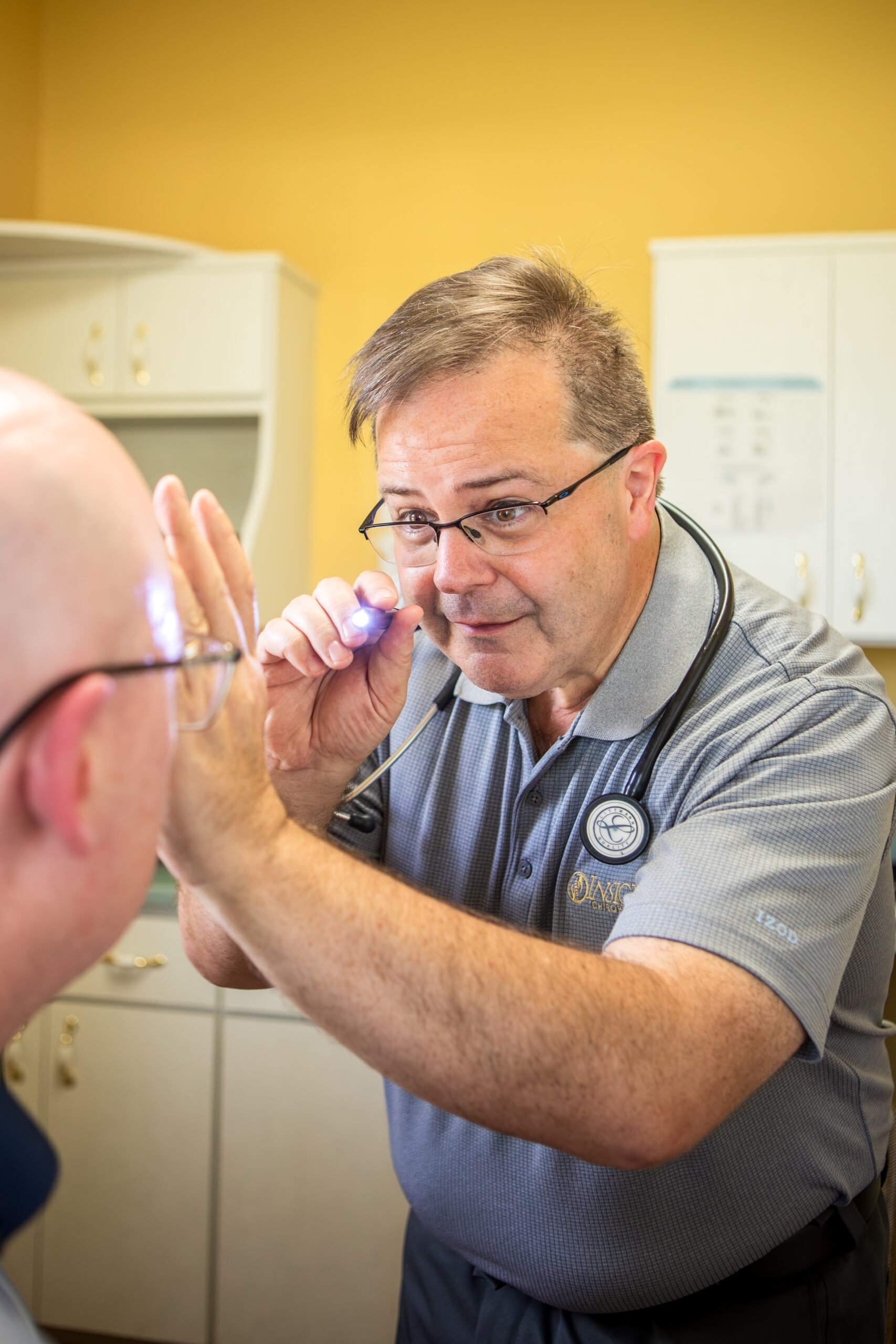 Dr. Michael Cox shining a penlight during a neurological examination at Insight Chiropractic in Ormond Beach
