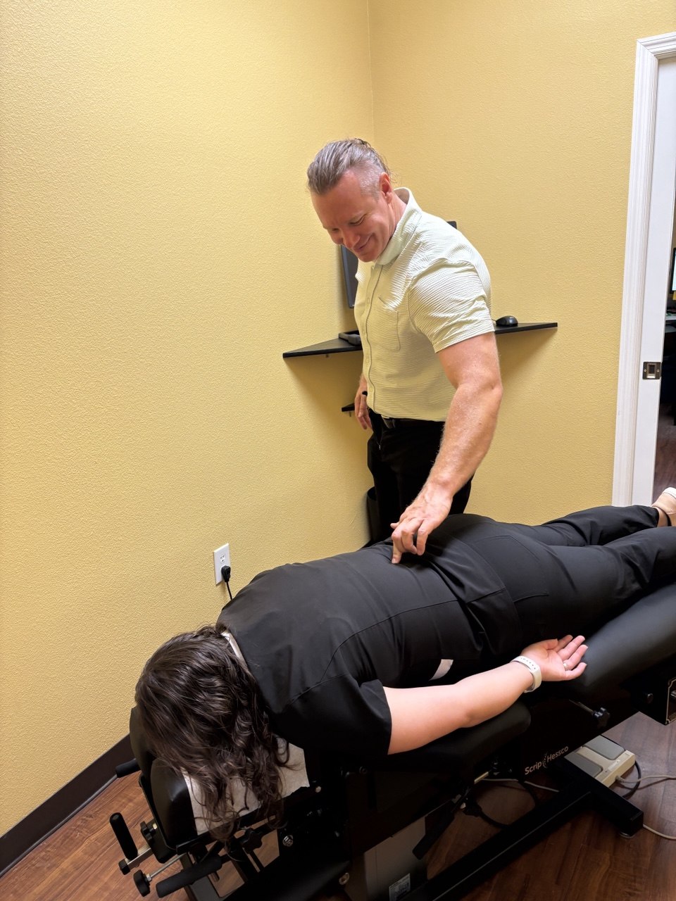 Dr. Christopher Fencl checking a patient's low back on the adjusting table at Insight Chiropractic in Ormond Beach