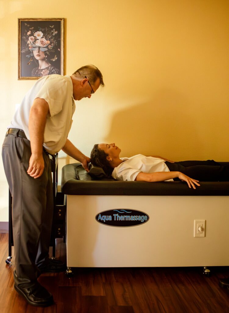 Dr. Michael Cox with a patient on the hydromassage table at Insight Chiropractic