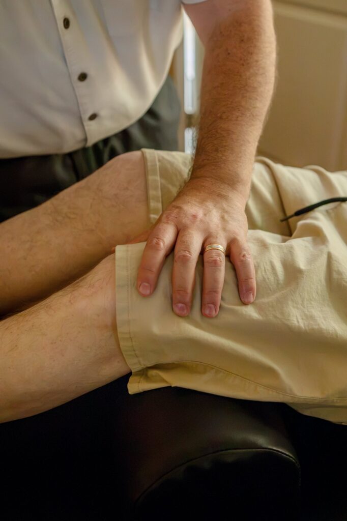 Dr. Michael Cox working on a patient's thigh muscles at Insight Chiropractic