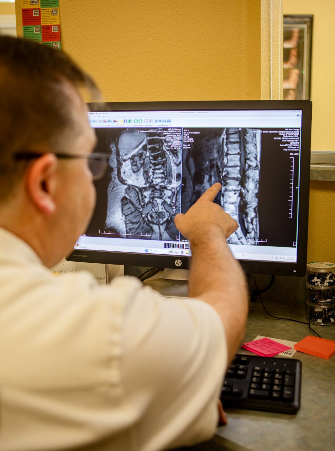 Dr. Michael Cox pointing to a lumbar MRI on his monitor at Insight Chiropractic