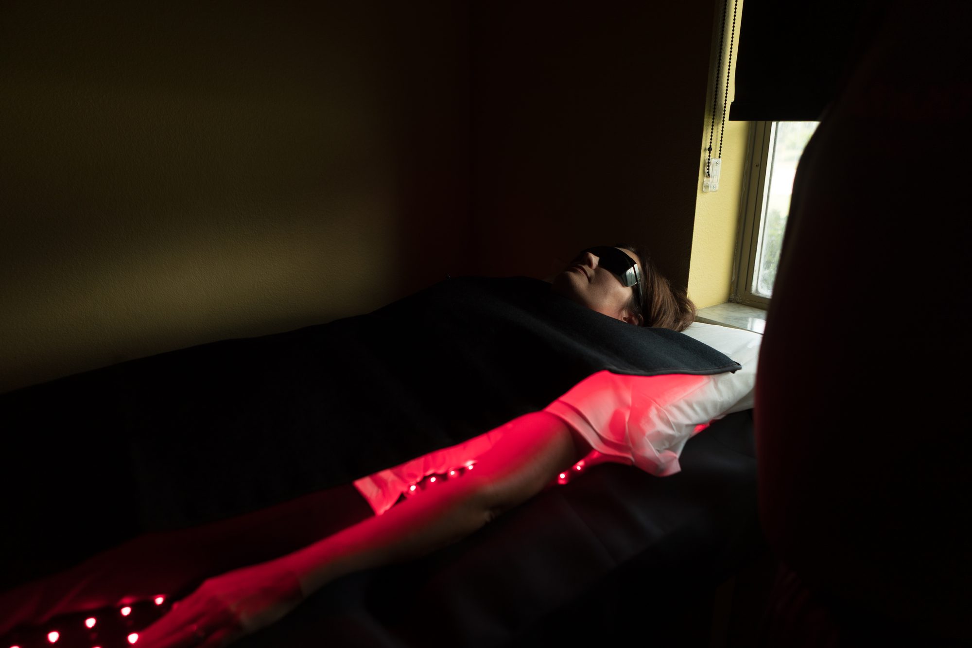A team member receiving red-light therapy in a treatment room at Insight Chiropractic