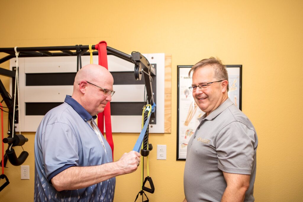 Dr. Michael Cox and a patient working with resistance bands at Insight Chiropractic