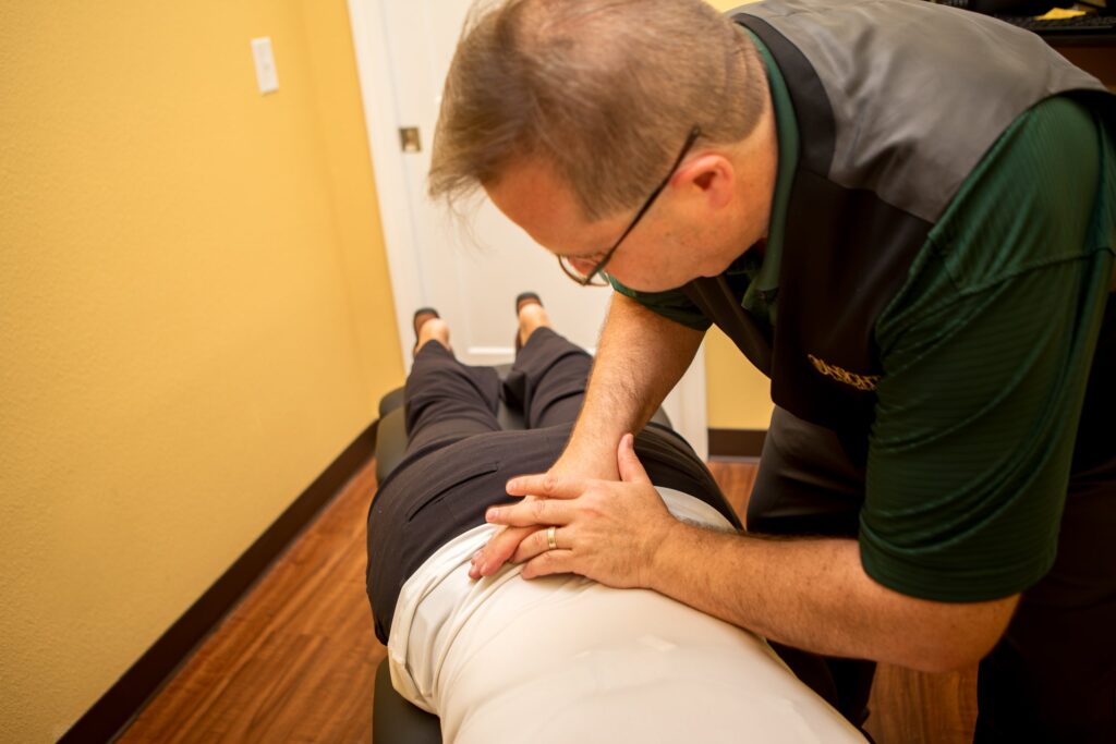 Dr. Michael Cox adjusting a patient's lower back at Insight Chiropractic in Ormond Beach