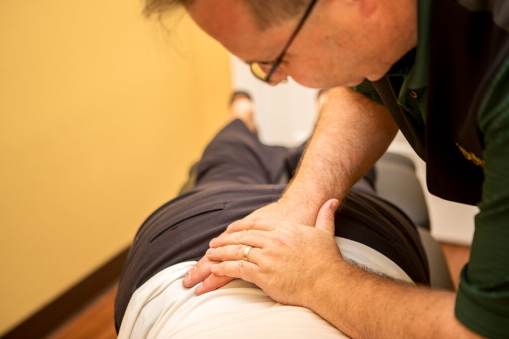 Dr. Michael Cox treating a patient's lower back on the table at Insight Chiropractic