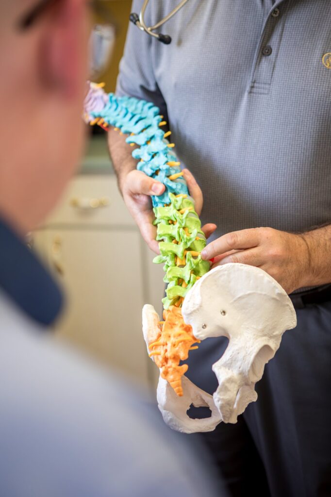 Dr. Michael Cox explaining posture on a spine model at Insight Chiropractic